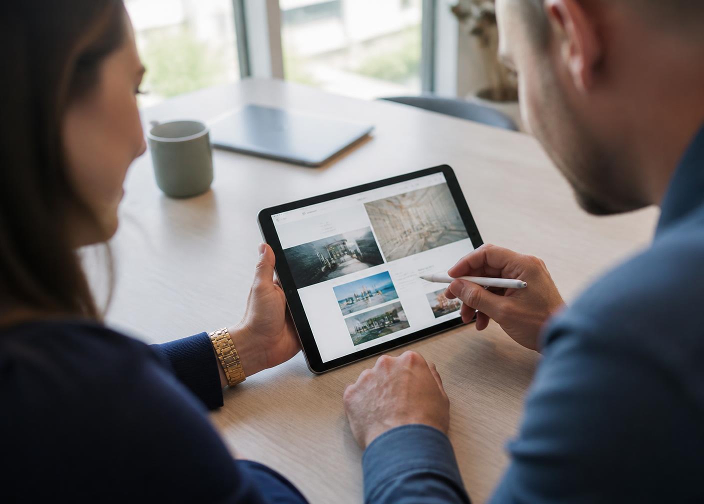 Two people reviewing a website design together on a tablet